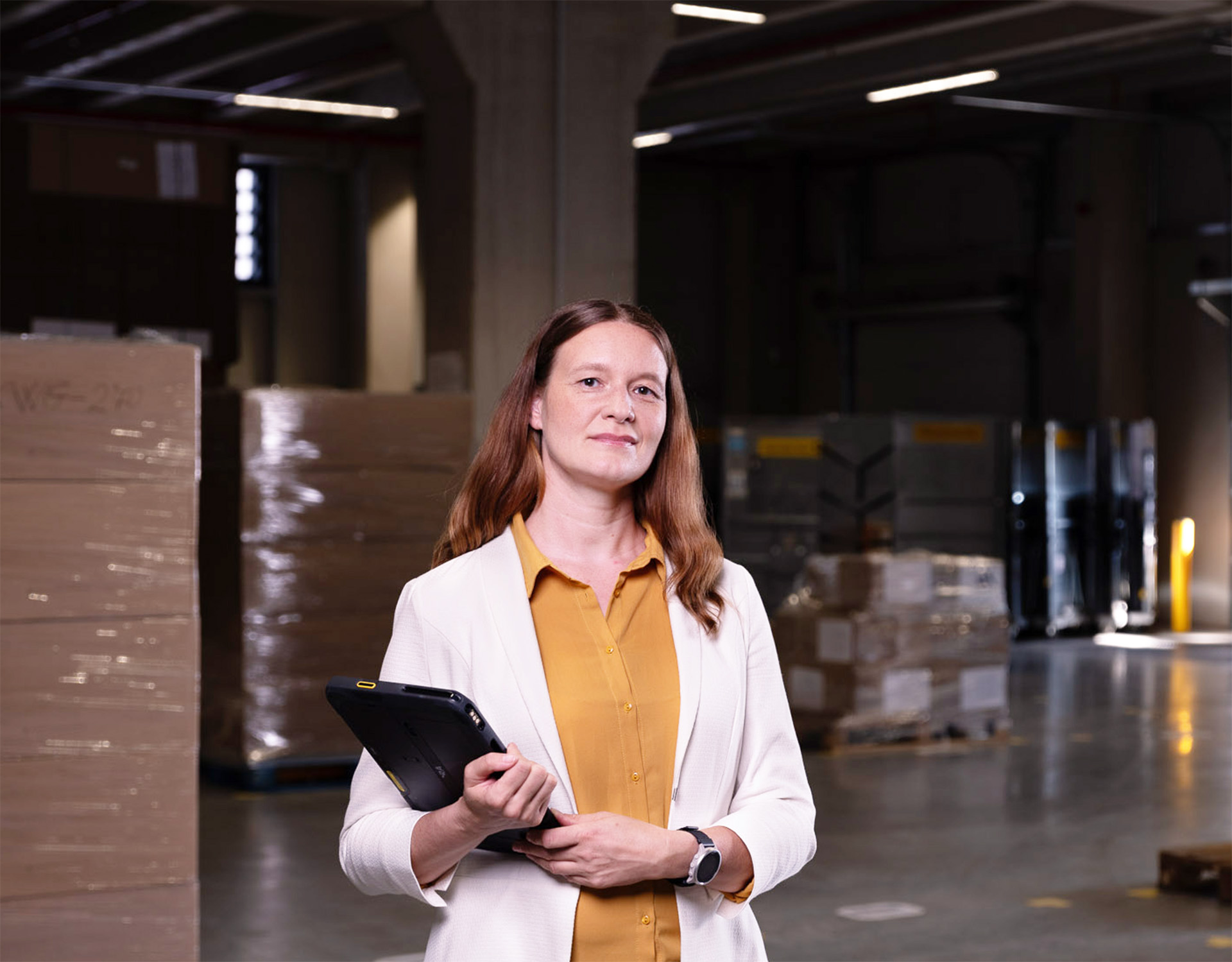 Mitarbeiterin, Christina Richter in einem Lager mit Tablet – symbolisiert die Prozessoptimierung und Supply Chain-Beratung von Greim Consulting, die Firmen bei der Verbesserung logistischer und e-commerce-naher Abläufe unterstützt.